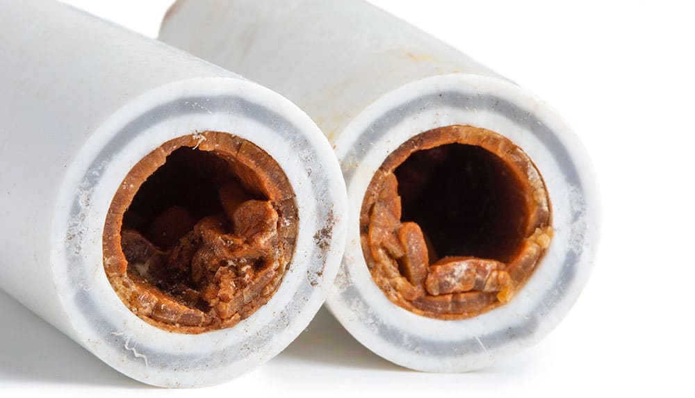 Ukázka pokročilého zanesení potrubí korozními úsadami a pevnými částicemi.